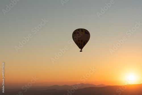 Hot air balloon in the sky during sunrise. Travel, dreams come true concept. Flying over the valley in Goreme, Cappadocia, Turkey