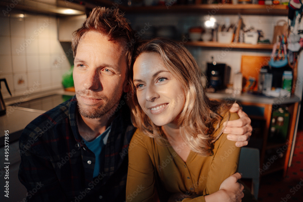 Couple sitting together in kitchen at home Couple sitting together in kitchen at home
