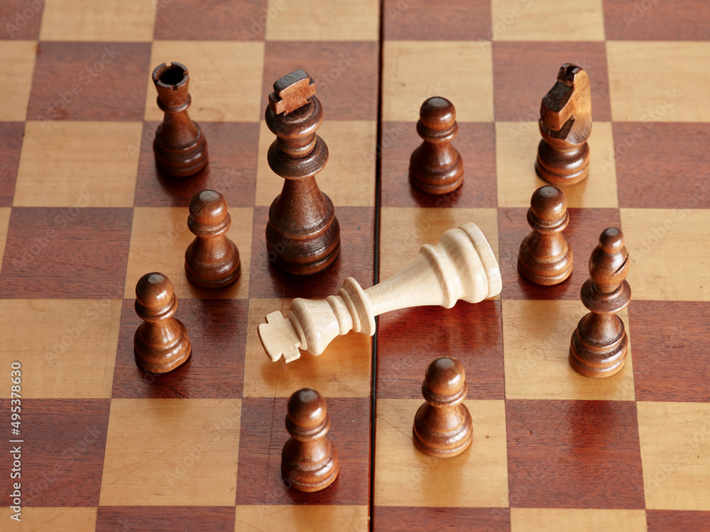 Fallen king is surrounded by the rival chess pieces. Fallen king is surrounded by the rival chess pieces.