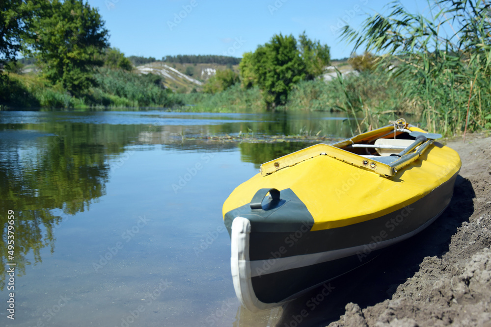 Fototapeta premium Yellow bright kayak lies on the bank of the Oskol river.