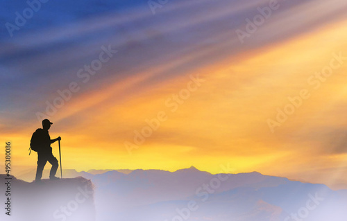 Success achievement concept. Silhouette of person standing on top of mountain.