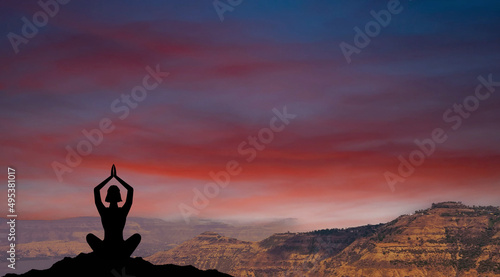 Yoga in nature. Silhouette of woman practice yoga meditation exercise outdoor. Young female sitting on mountains for relaxed yoga posture in the morning, mental health care, relaxation, meditation.