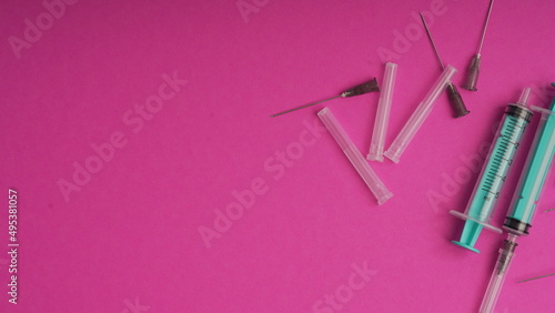 medical disposable syringe for injection in the hospital. medical devices on a pink background