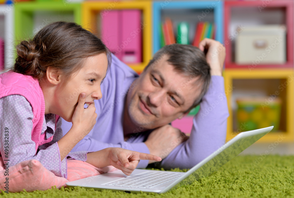 Portrait of father with little daughter using laptop Portrait of father with little daughter using laptop