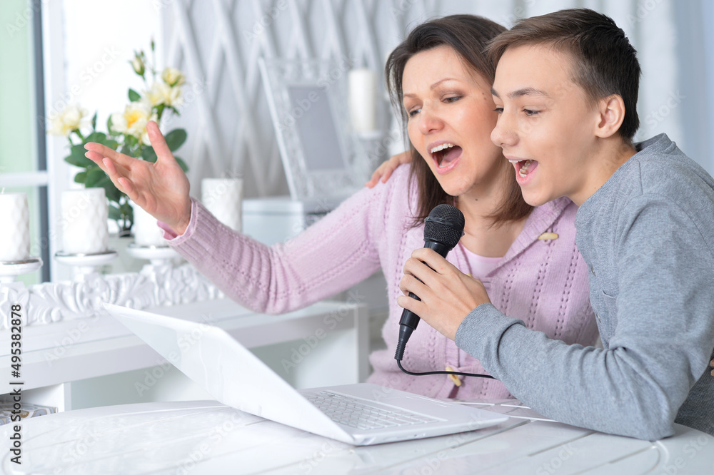 Portrait of emotional mother and son singing karaoke Portrait of emotional mother and son singing karaoke