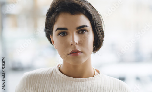 Portrait of beautiful young woman with brown eyes and short hair.