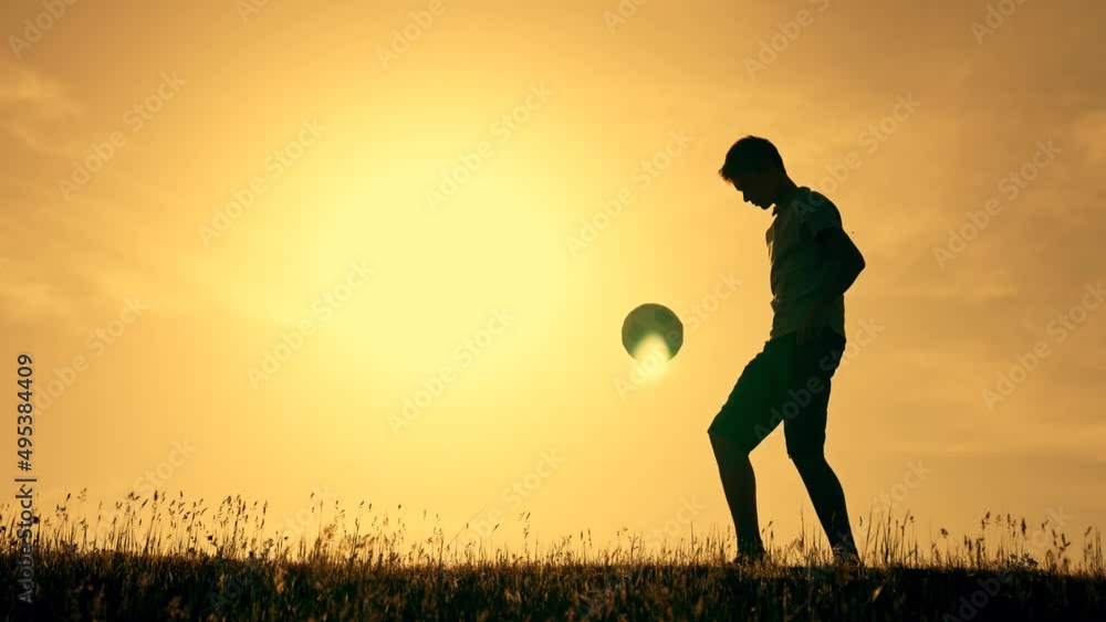 Boy with soccer ball. Child in park plays at sunset.Boy juggles soccer ...