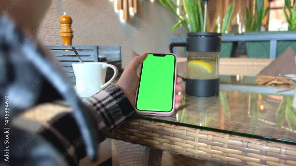 Woman's Hand Holding A Mobile Telephone With A Vertical Green Screen In Tram Mobile Phone Smartphone Telephone Green Screen Monitor For Internet. High quality photo Woman's Hand Holding A Mobile Telephone With A Vertical Green Screen In Tram Mobile Phone Smartphone Telephone Green Screen Monitor For Internet. High quality photo