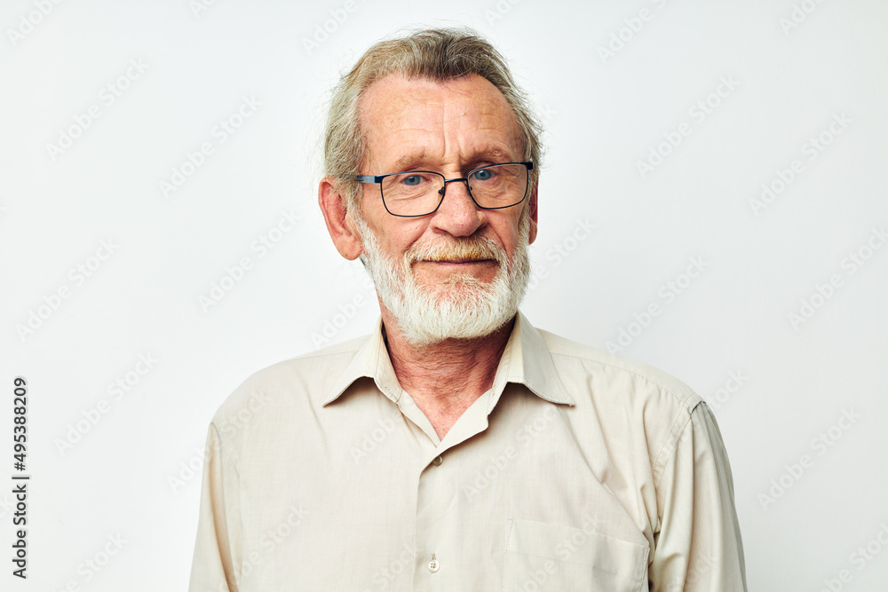 Obraz premium Photo of retired old man with a gray beard in a shirt and glasses light background