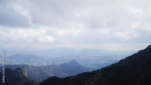 The curved ridges, the city below the mountains, and the clouds.
