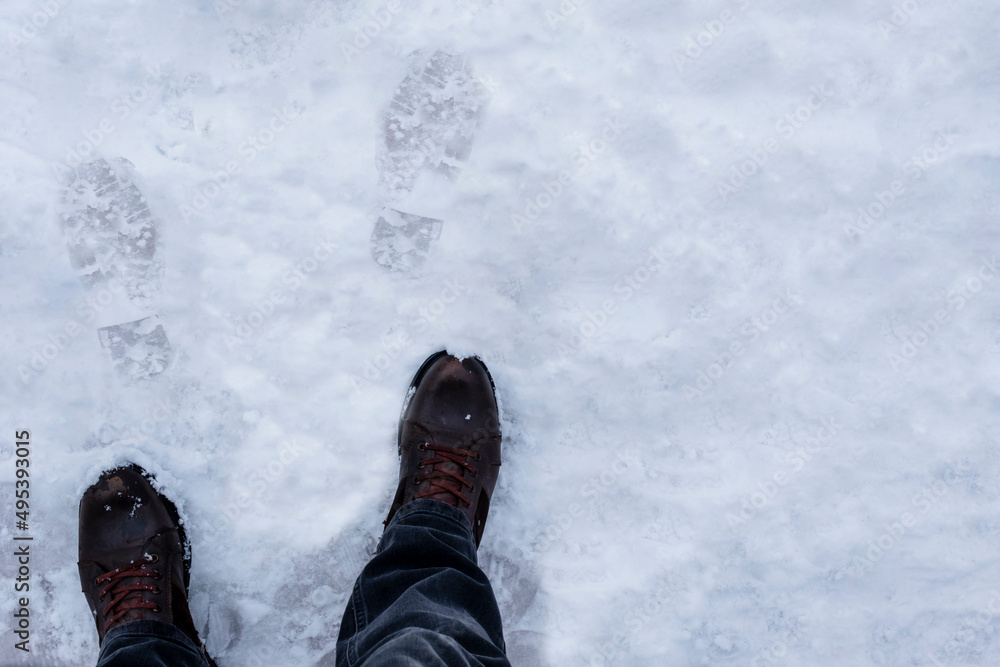 footprints in the snow, and the boots that own them. selective focus boots footprints in the snow, and the boots that own them. selective focus boots