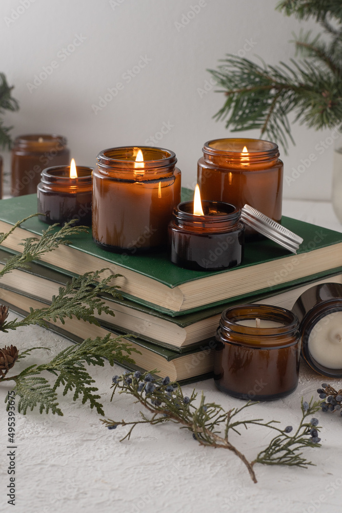 A set of different aroma candles in brown glass jars. Scented handmade candle. Soy candles are burning in a jar. Aromatherapy and relax in spa and home. Still life. Fire in brown jar A set of different aroma candles in brown glass jars. Scented handmade candle. Soy candles are burning in a jar. Aromatherapy and relax in spa and home. Still life. Fire in brown jar