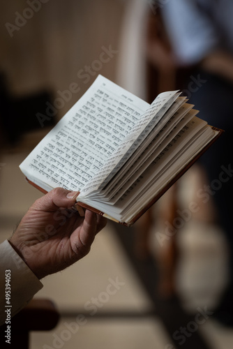 A man holds a siddur or Jewish prayer book during services in a synagogue in Israel.