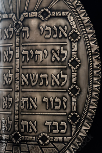 A pewter breastplate inscribed with the 10 commandments covers a Sefer Torah or Jewish scroll of the five books of Moses. photo