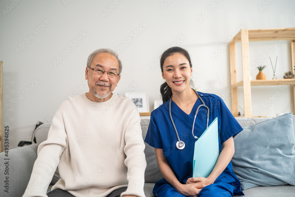 Obraz premium Portrait of Asian caregiver nurse sit on sofa and take care senior man