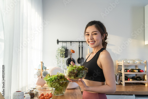 Portrait of Asian attractive woman hold salad bowl and look at camera.