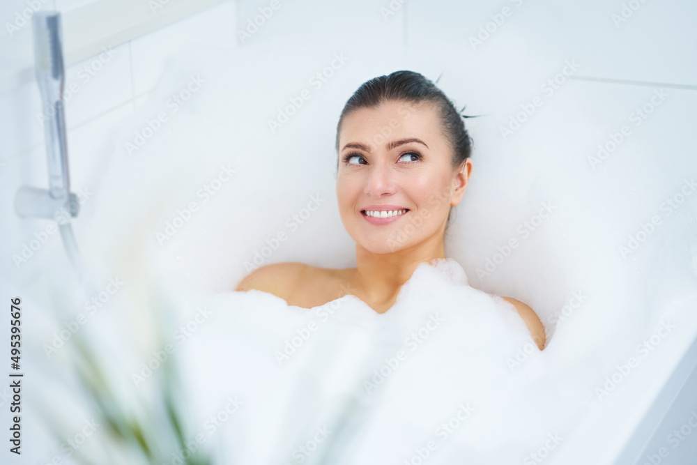 Naklejka premium Young nice brunette woman having bath in bathtub
