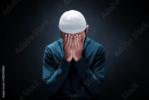 Muslim man praying on dark background