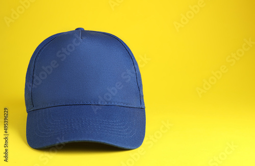 Photography Stylish blue baseball cap on yellow background. Space for text