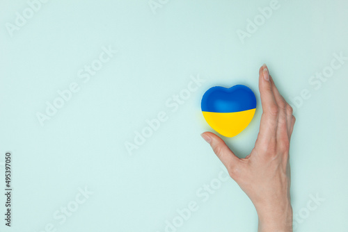 Heart with print the national flag of ukraine in female hand. Flat lay. Copy space.