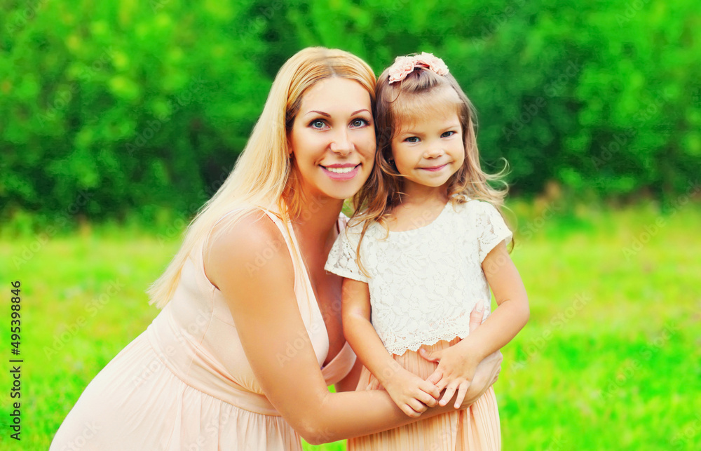 Portrait of happy young mother with little girl baby walking outdoors in summer park Portrait of happy young mother with little girl baby walking outdoors in summer park