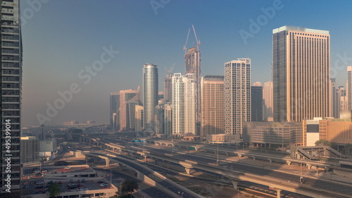 Fototapeta Naklejka Na Ścianę i Meble -  Dubai Marina skyscrapers and Sheikh Zayed road with metro railway aerial timelapse, United Arab Emirates