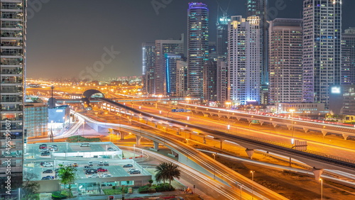 Dubai Marina skyscrapers and Sheikh Zayed road with metro railway aerial all night timelapse, United Arab Emirates