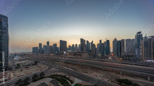 Dubai Marina skyscrapers and Sheikh Zayed road with metro railway aerial day to night timelapse, United Arab Emirates © neiezhmakov