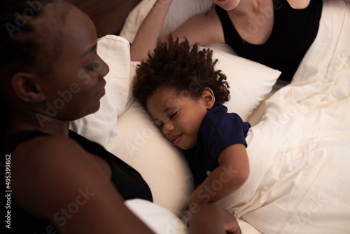Calm happy little boy sleeping in bed of his parents, co-sleeping and bed time routine concept