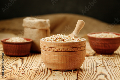 Barley groats in bowls and bags on a wooden background. High quality photo