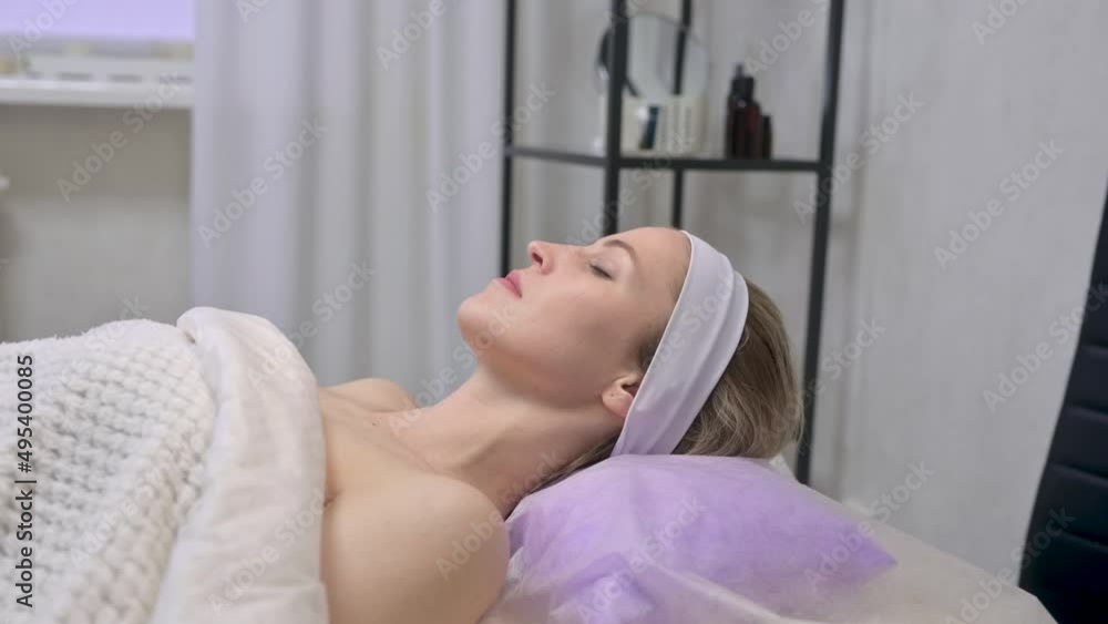 Young beautiful woman is massaged face in spa salon. Face massage essential oil for skincare Young beautiful woman is massaged face in spa salon. Face massage essential oil for skincare