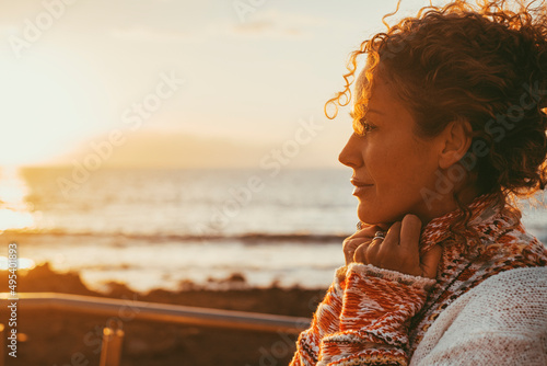 Foto Enjoyed and serene lady dreaming and thinking outdoor with ocean beach and sunset light in background