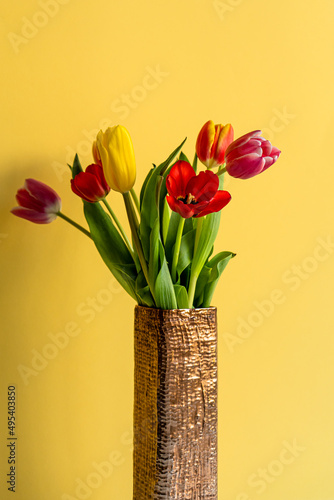 Multicolored tulips on yellow background with copy space for text. Bouquet of spring flowers. Isolated on yellow background.  Mother's Day, Valentines, Anniversary, Easter, Birthday.