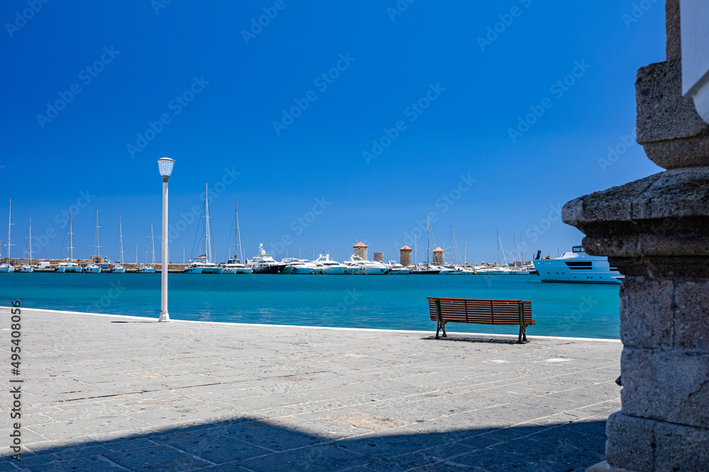 Obraz premium Rhodes Windmills in the Mandraki harbor and marina. Sightseeing in the old town. Rhodes, Greece
