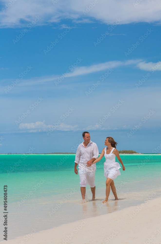 Attractive Caucasian couple walking on a tropical beach