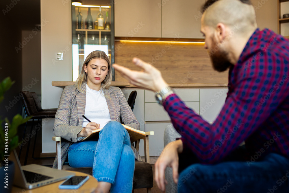 Young man talking to female psychologist during session. Young man talking to female psychologist during session.