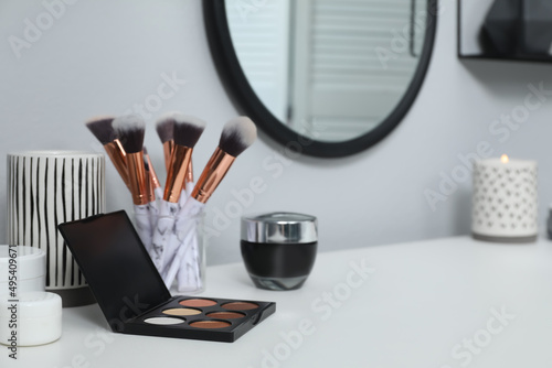 Wallpaper Mural Stylish round mirror hanging above dressing table, focus on cosmetic products. Space for text Torontodigital.ca