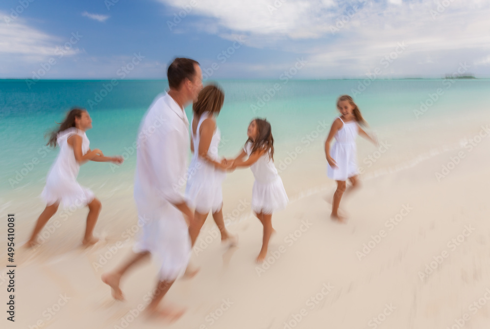 Happy Caucasian family white clothes running along beach