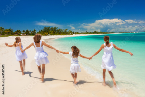 Happy Caucasian family in white walking holding hands