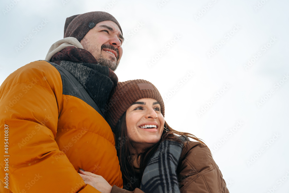 Young couple in love outdoor in snowy winter forest.