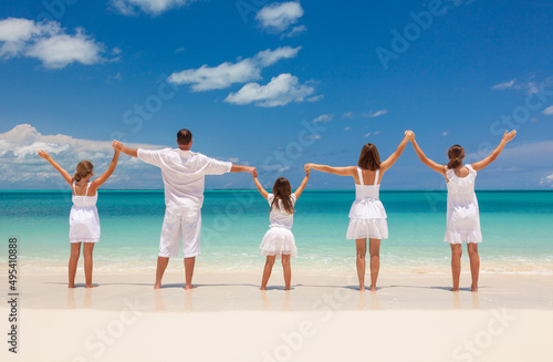 Happy Caucasian family in white standing holding hands