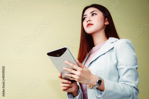 PortraitAsian business woman using a laptop in a casual office room looking at the outside. photo