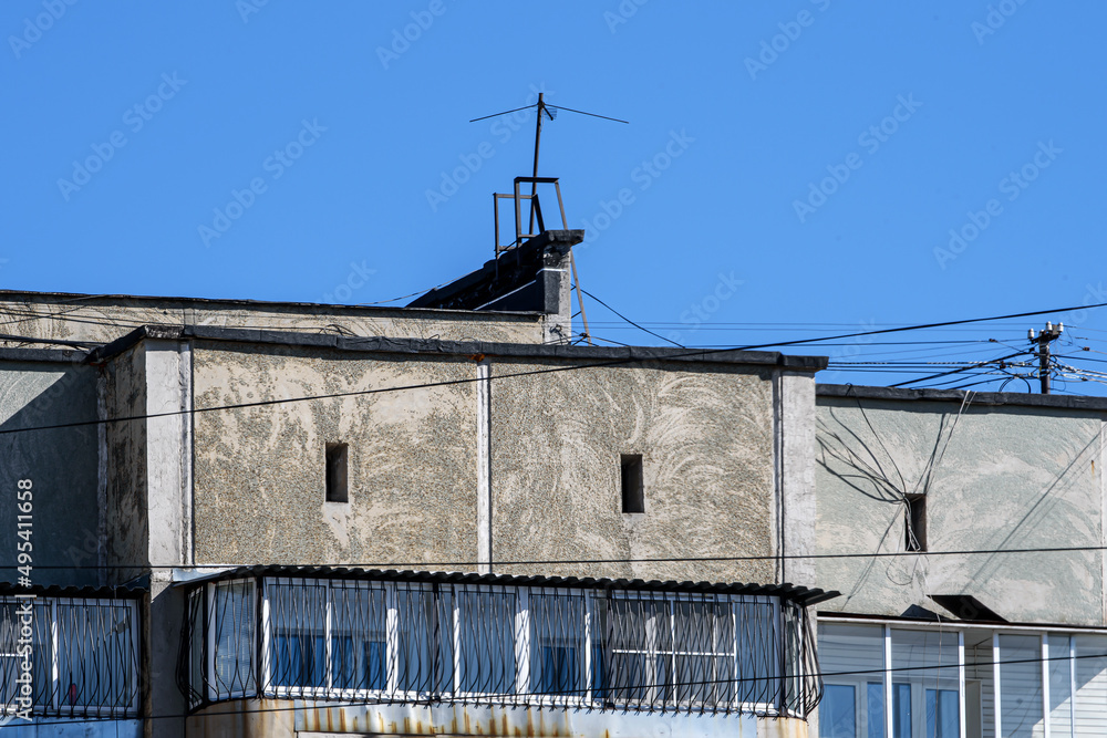 Fragment of the upper part of a multi-storey residential building against the blue sky Fragment of the upper part of a multi-storey residential building against the blue sky