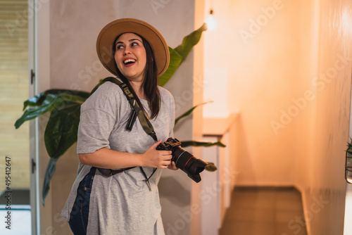 Wallpaper Mural Chica joven guapa con sombrero y cámara de fotos sonriendo en habitación de hotel Torontodigital.ca