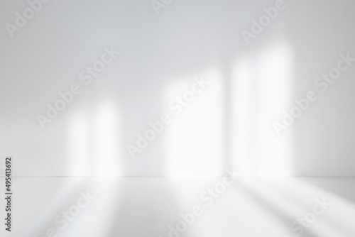 Abstract white studio background for product presentation. Empty room with shadows of window. Display product with blurred backdrop. Soft focus