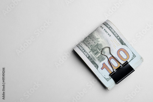 Dollar banknotes with paper clip on white background, top view