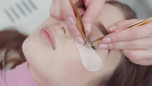 The master performs the procedure of eyelash extensions photo