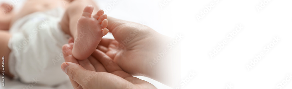 Mother massaging her cute baby with oil, closeup. Banner design with space for text Mother massaging her cute baby with oil, closeup. Banner design with space for text