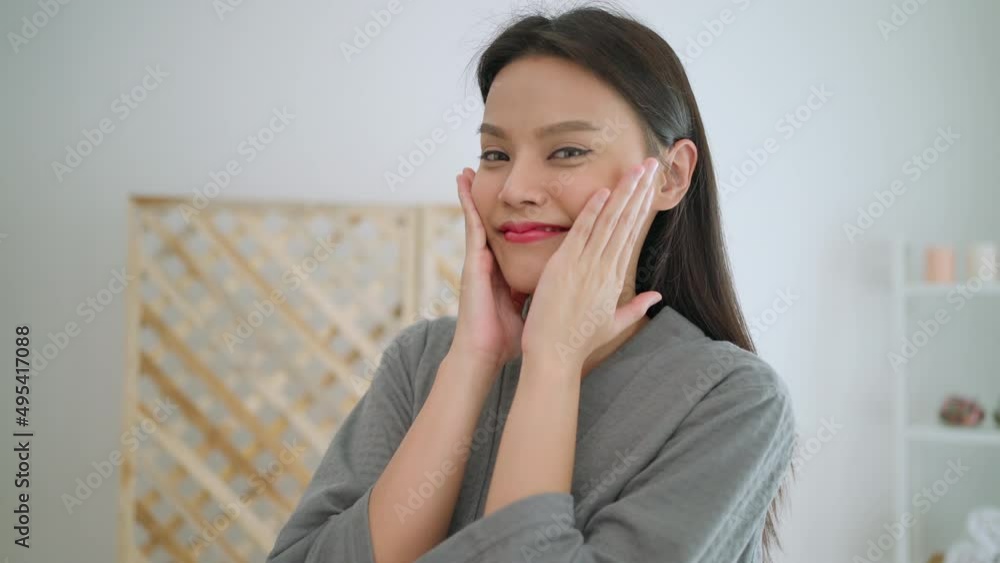 Beautiful attractive woman massage on her face and looking at camera. Feeling happy and relax after apply serum. Enjoy natural clean soft moisturized. Beauty and skin care treatment concept. Beautiful attractive woman massage on her face and looking at camera. Feeling happy and relax after apply serum. Enjoy natural clean soft moisturized. Beauty and skin care treatment concept.