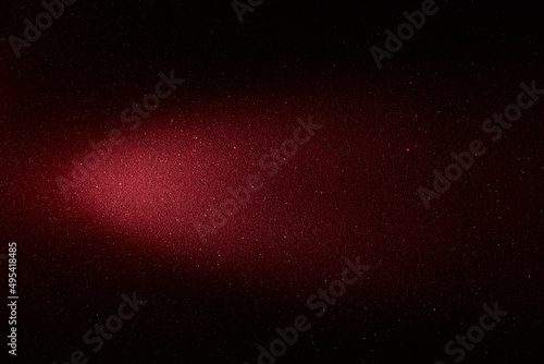 On a black background, a gradient red beam of light